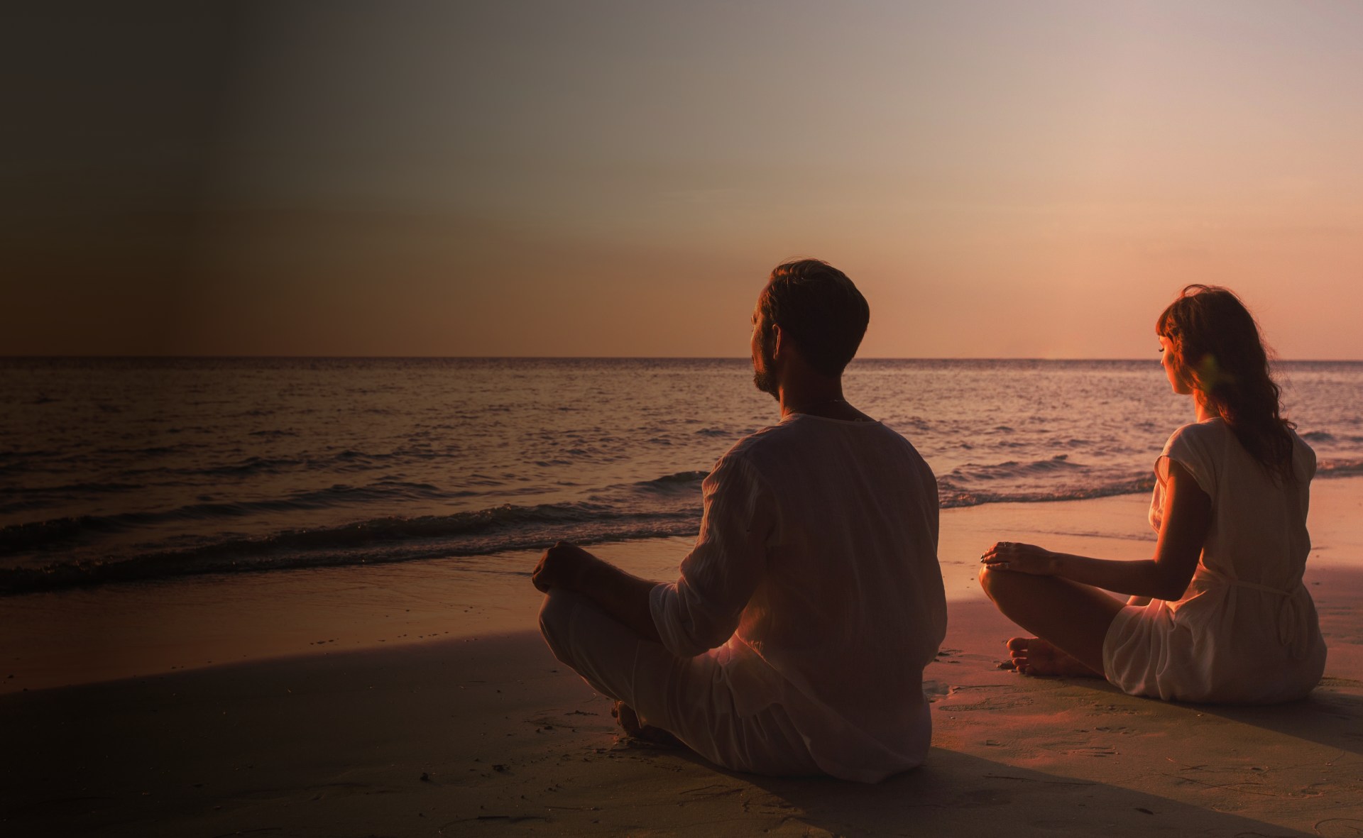 Man and woman sitting and doing yoga