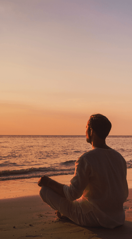 Man sitting in the beach doing yoga