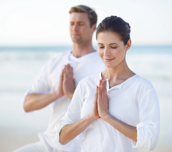 Young couple wearing white and doing yoga